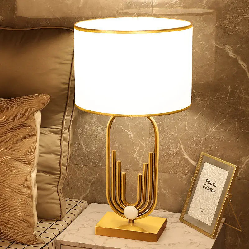 Lampe de table Raynova design doré avec base architecturale et abat-jour cylindrique en tissu - vue 8